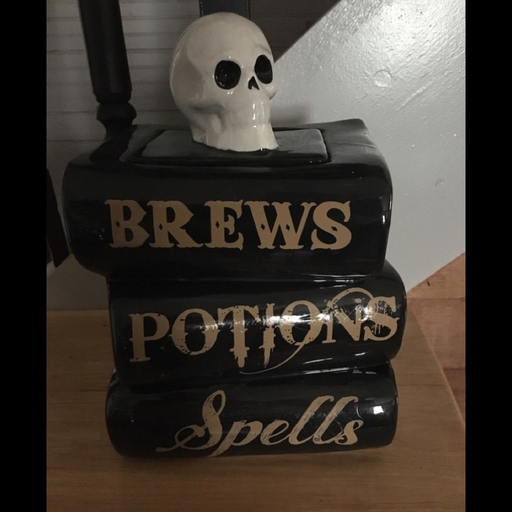 Cookie Jar with skull head on top of a stack of books.